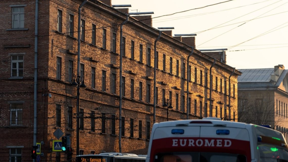 a bus driving down a street next to tall buildings